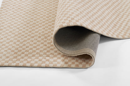 Beige-tan checkerboard rug with plush pile, rolled to show gray backing; ideal for modern living spaces.