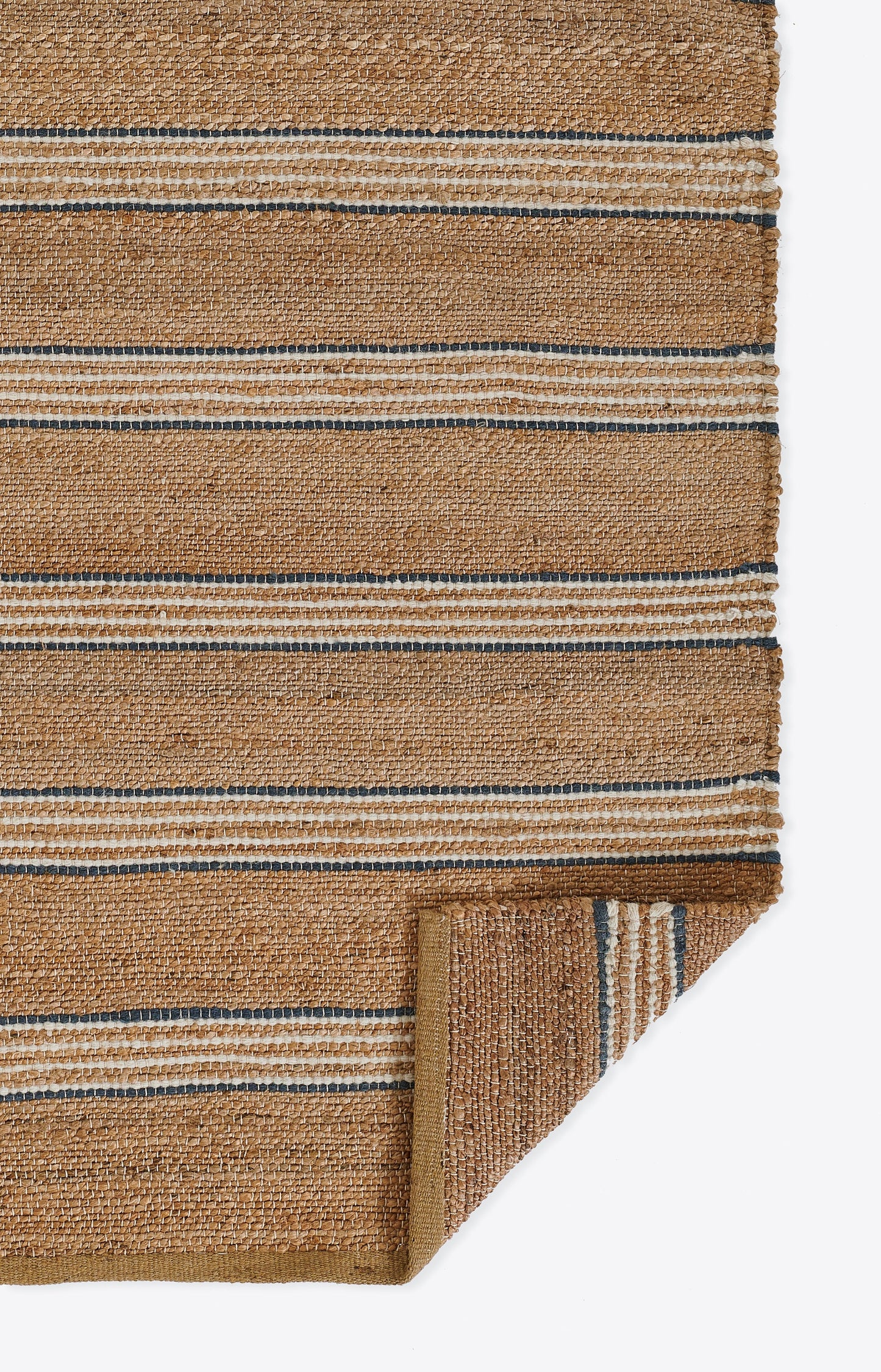Natural jute rug with tan and beige stripes and thin blue lines; flat-weave, rustic coastal style, folded corner.