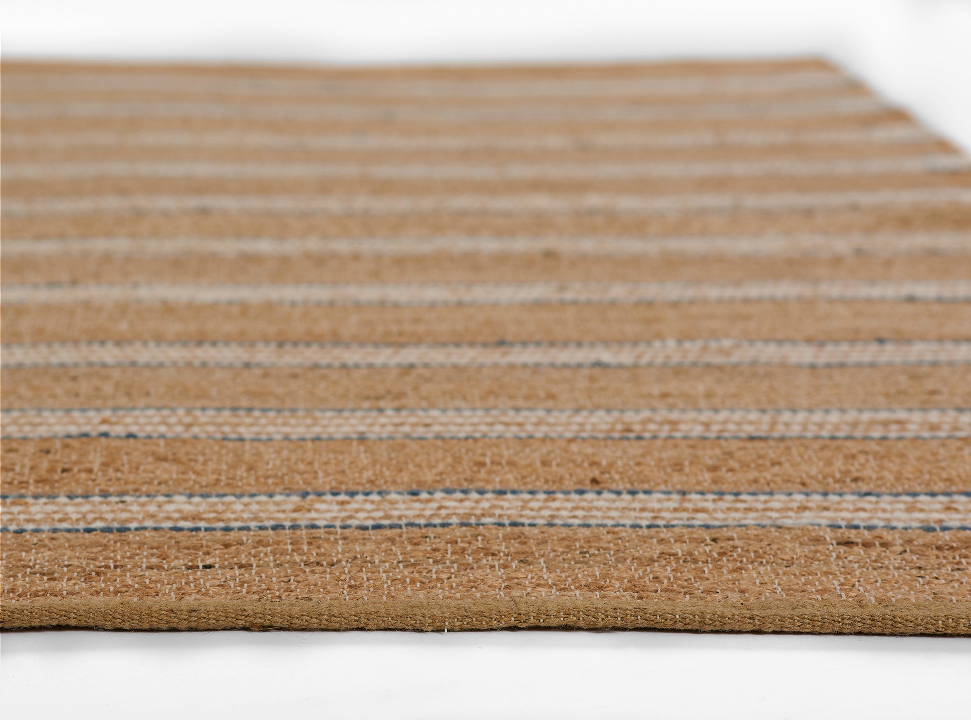 Natural jute runner rug with tan base and blue striped bands, flat-woven texture.