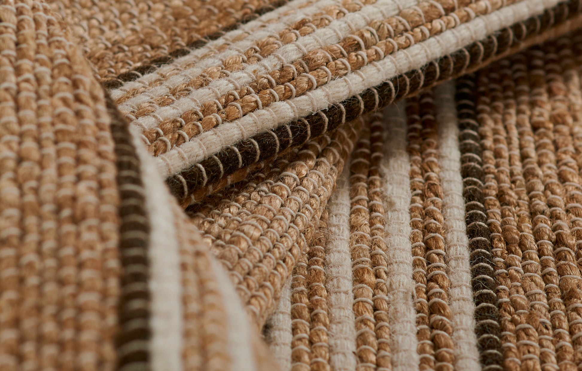 Natural brown and beige striped woven rug with chunky looped texture and jute-like fibers.