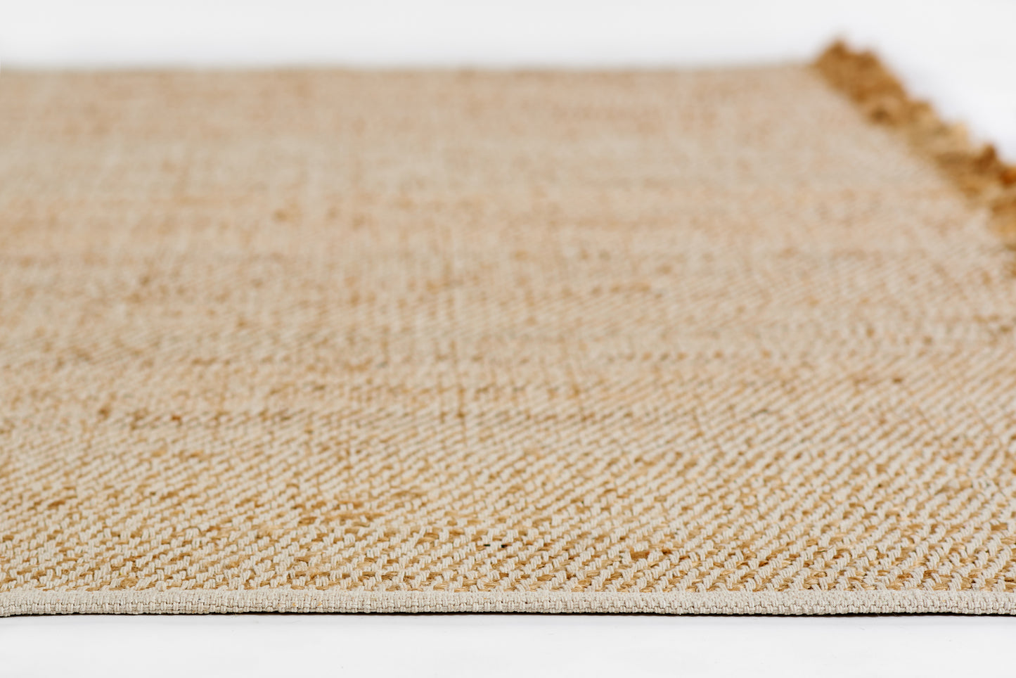 Natural beige woven jute rug with tight textured weave and fringed edge.