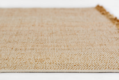 Natural beige woven jute rug close-up with textured weave and fringe along edge.