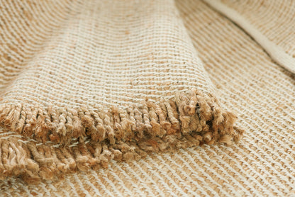 Natural beige jute runner rug with chunky woven texture and fringe tassels along the edge