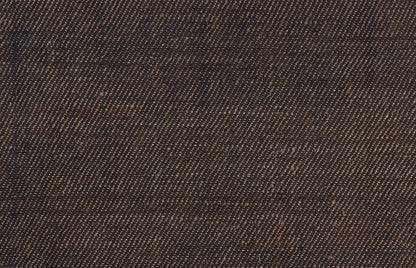 Dark blue denim twill fabric close-up with orange-brown flecks and textured weave.