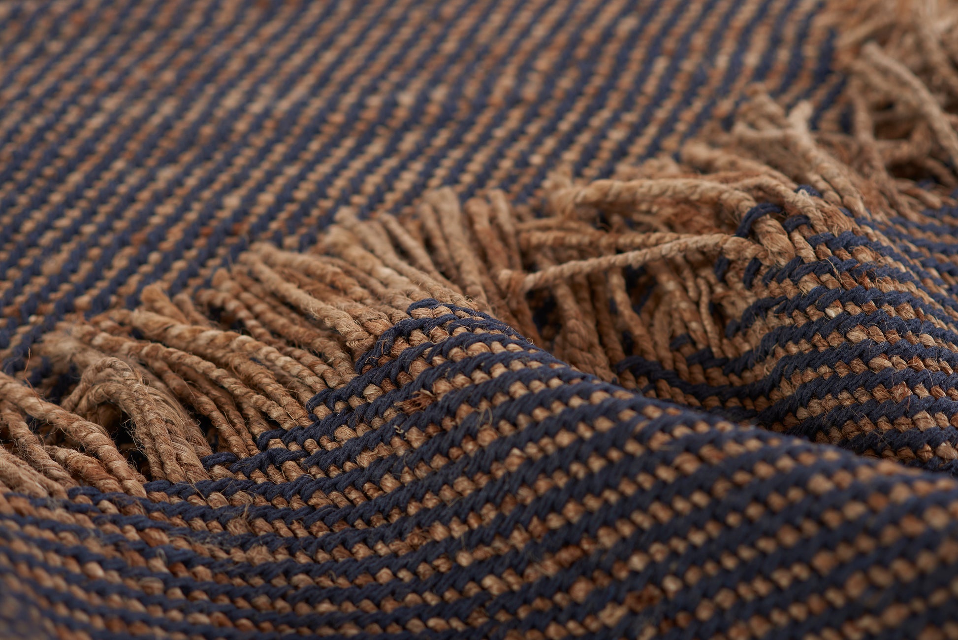 Blue and tan striped woven runner rug with fringed edges and soft texture, 2' x 8'.