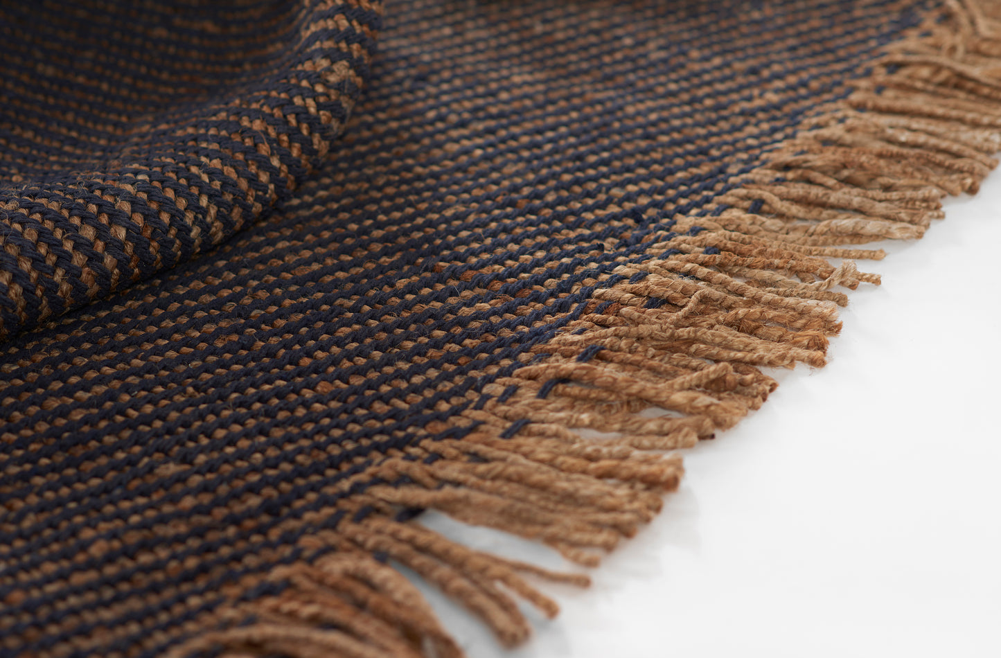 Navy and tan woven rug with tan fringed ends, textured striped pattern.