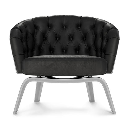 Black tufted fabric lounge chair with button details and curved metal sled legs.