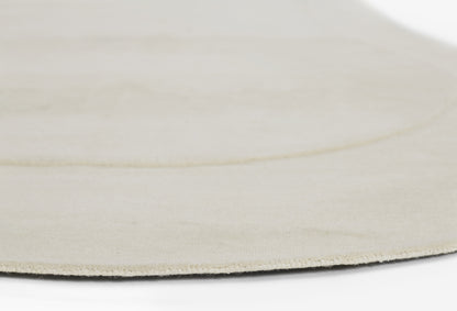 Beige round rug with soft suede-like pile, minimalist floor decor.