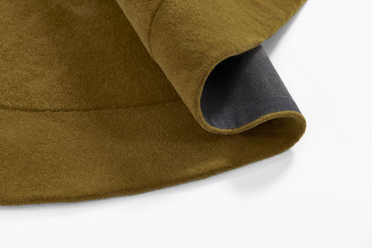 Mustard wool rug with a dark navy border and curved rolled edge.