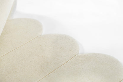 Ivory suede-like fabric petals arranged in overlapping rounded shapes; soft texture, close-up.
