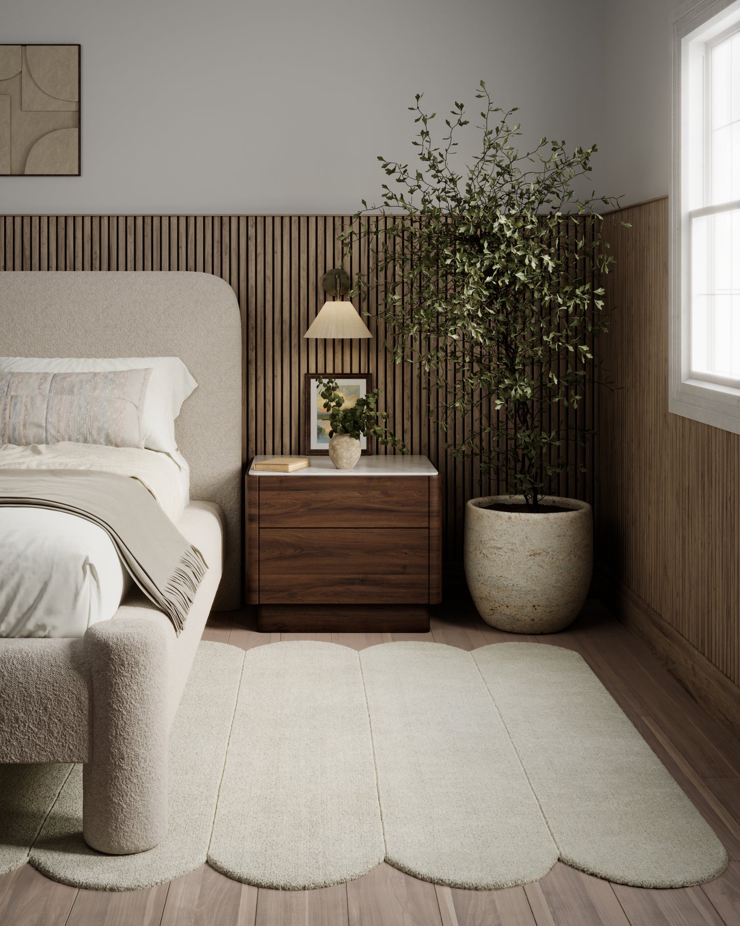Neutral bedroom with beige upholstered bed, wooden nightstand, large potted tree, and scalloped beige runner rug.