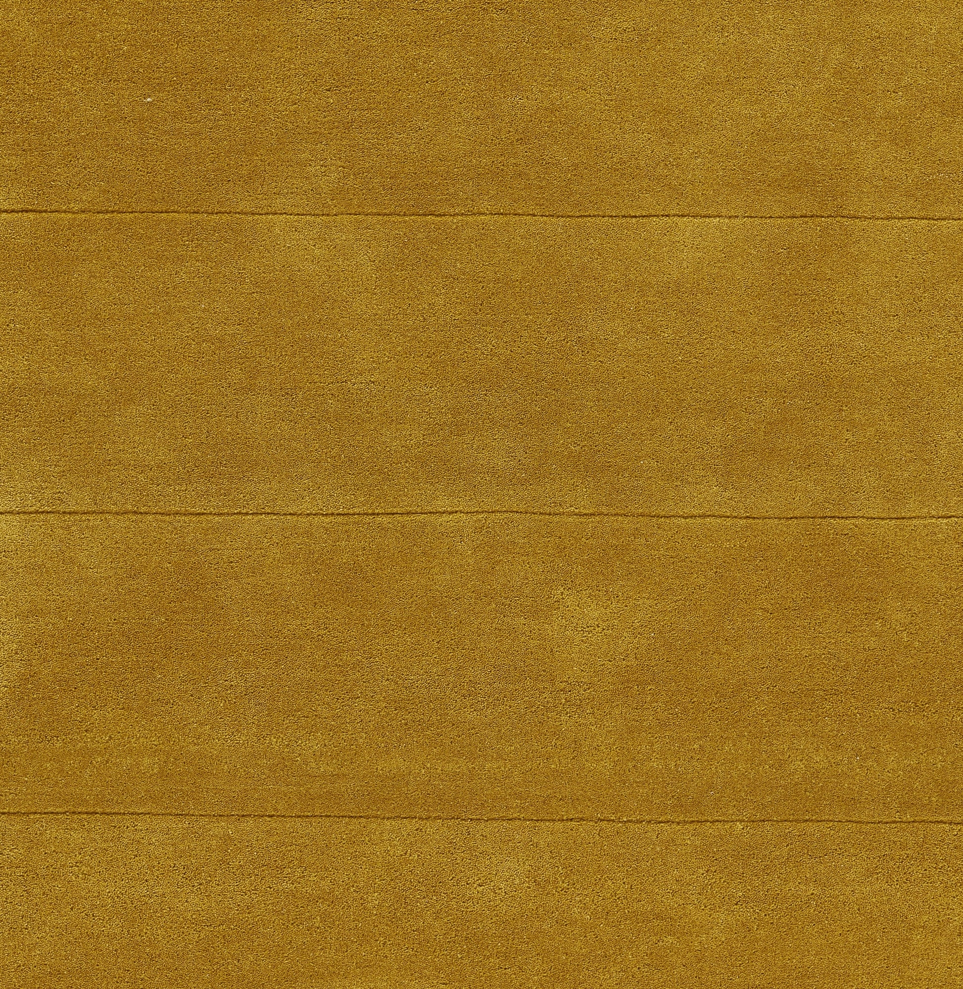 Golden-brown textured rug with subtle grain and visible horizontal seams.