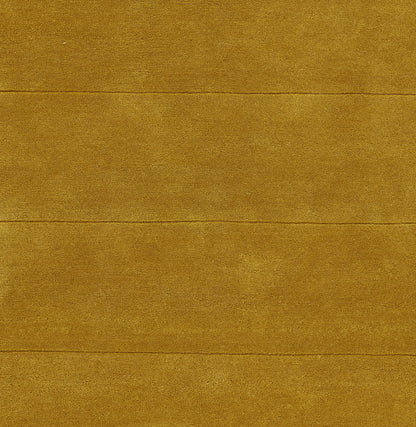 Golden-brown textured rug with subtle grain and visible horizontal seams.