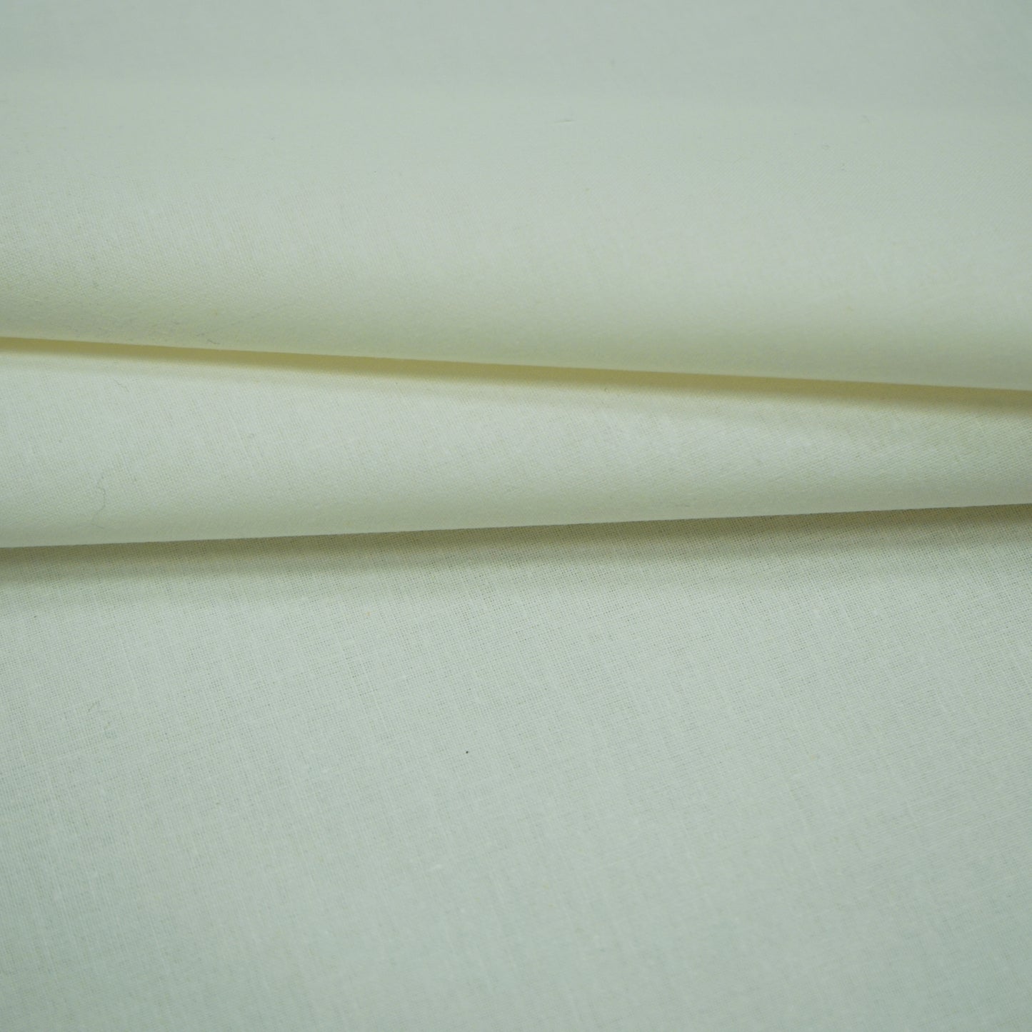 Cream fabric with subtle weave, folded layers and soft drape for cloak or garment.