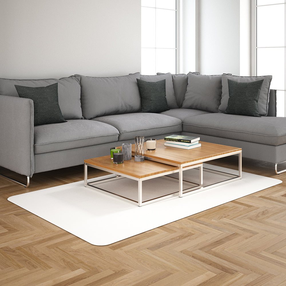 Charcoal fabric L-shaped sofa with dark cushions and a two-tier wooden coffee table with a metal frame on a white rug.