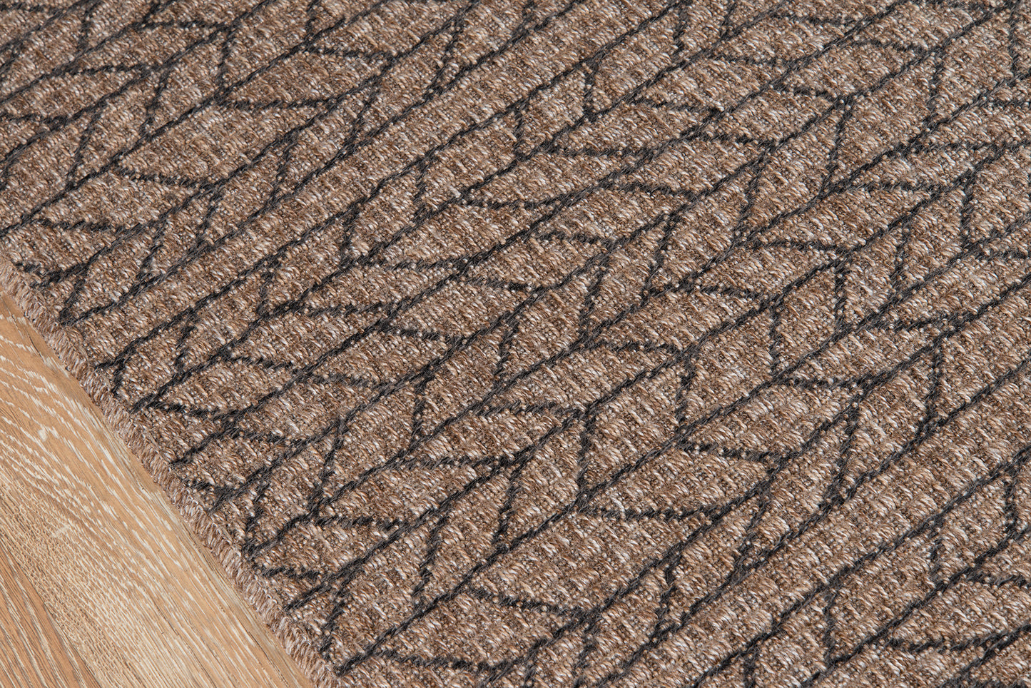 Tan & brown woven rug with chevron loop pattern & textured fiber surface.