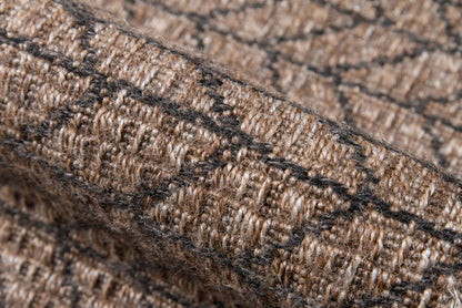 Tan-brown woven rug texture with dark stripes; chunky boucle yarn, rustic cozy style.