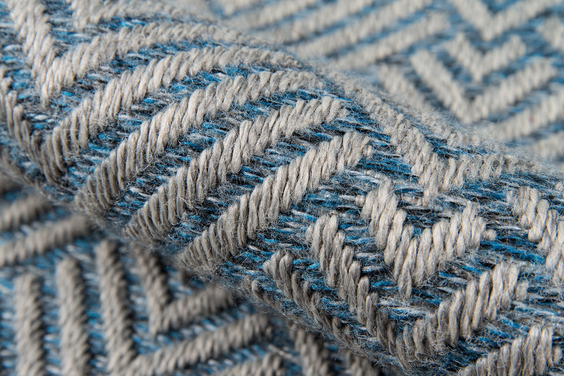 Close-up of blue and white chevron woven rug with chunky yarn.
