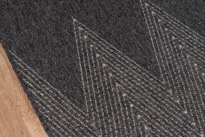 Dark charcoal woven rug with light grey chevron triangles; modern geometric area rug.
