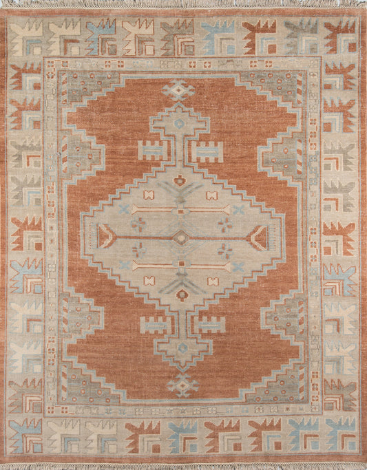 Rust-orange kilim-style area rug with pale blue and ivory geometric medallion, fringed ends; ideal for living room decor.