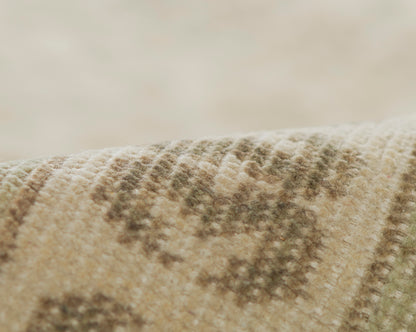 Close-up of a beige textured rug with brown geometric pattern & soft woven fibers.