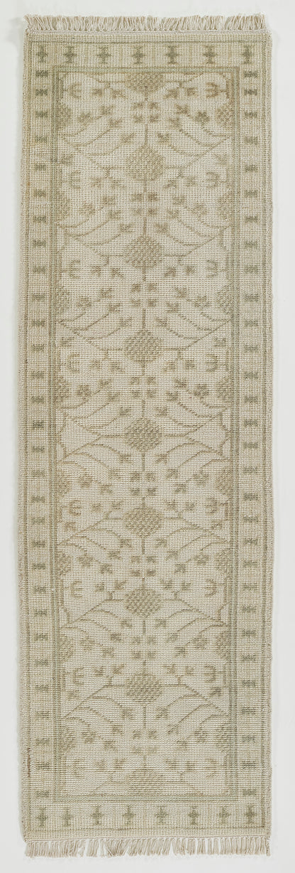 Neutral beige runner rug with olive border and geometric botanical motifs, fringed ends, flatwoven kilim-style.