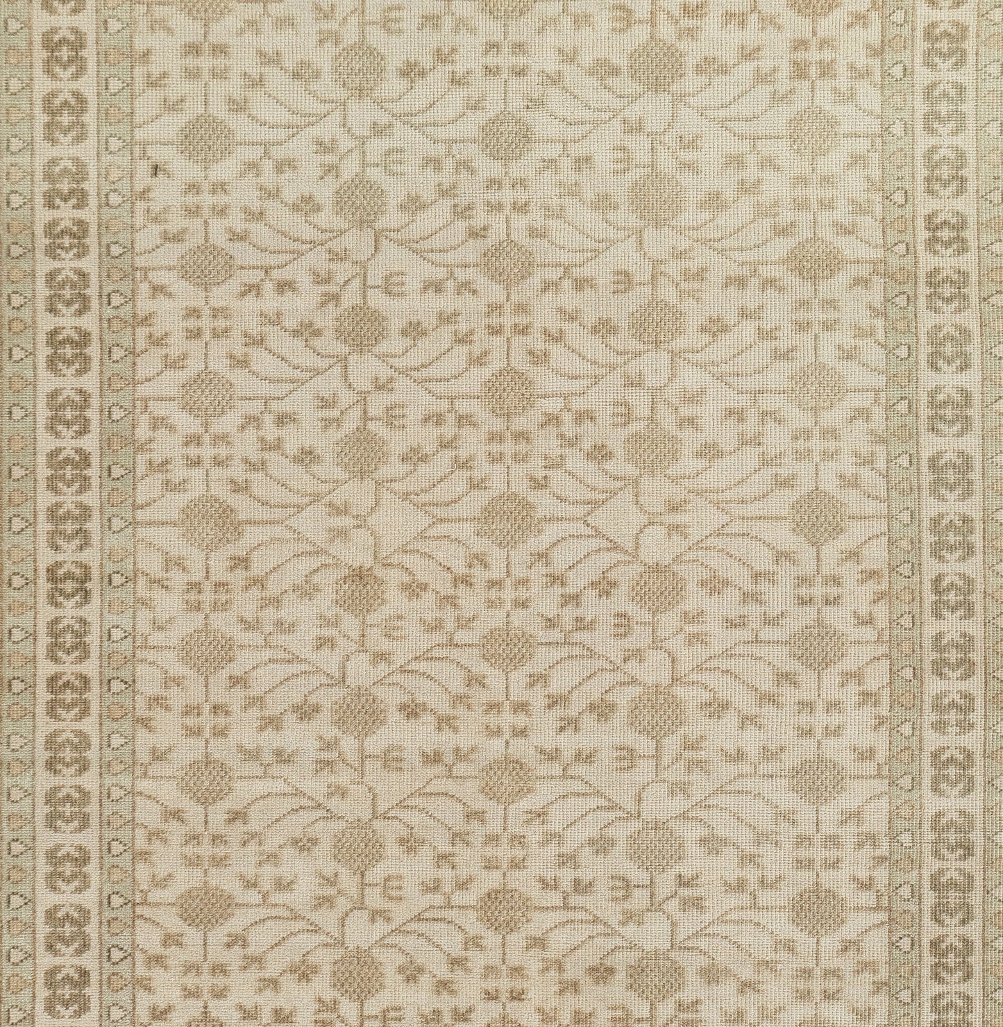 Beige cream rug with repeating circular medallions and delicate floral vines, framed by a decorative border.