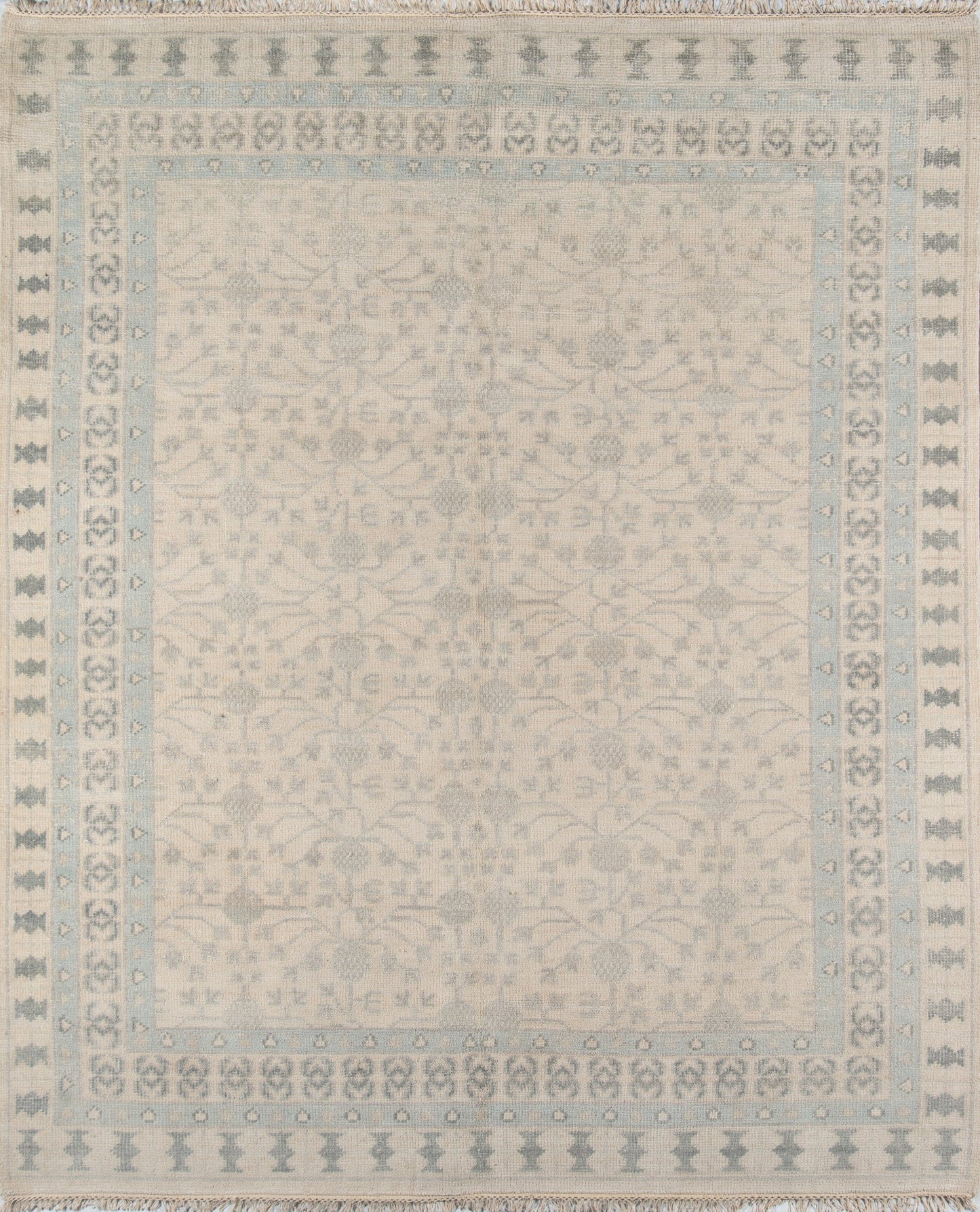 Ivory rug with pale blue border and delicate floral damask center; fringed edges.