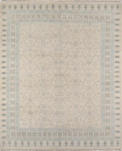 Ivory rug with pale blue border and delicate floral damask center; fringed edges.