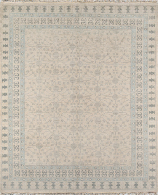 Ivory rug with pale blue border and delicate floral damask center; fringed edges.