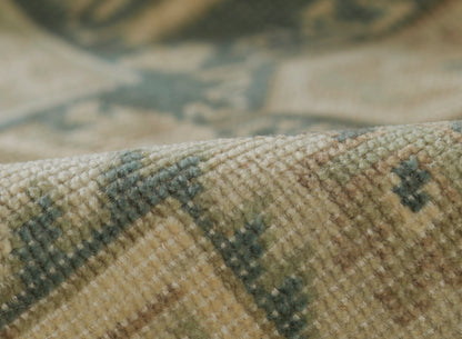 Close-up of a muted green and beige woven runner rug with a geometric motif and soft textured pile.