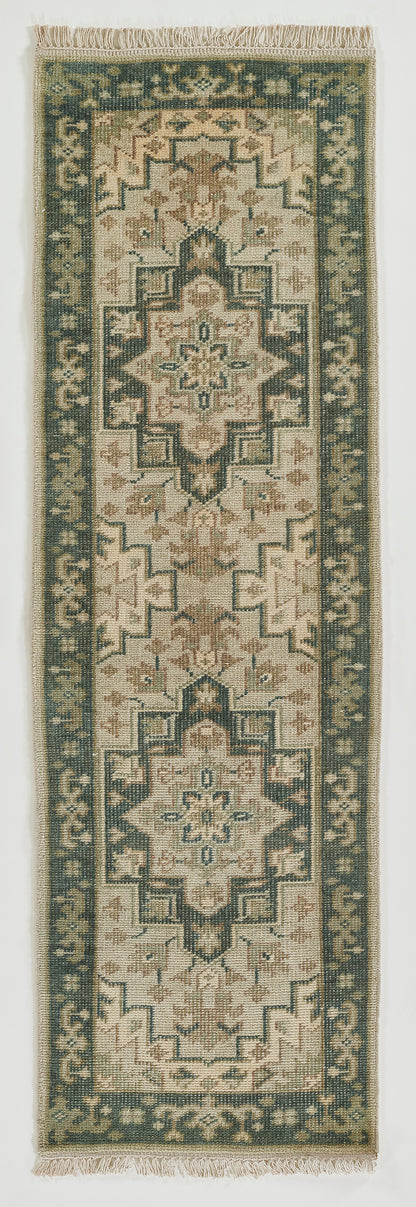 Long rectangular oriental rug runner with cream field, muted sage green border, geometric central medallion and fringed ends.
