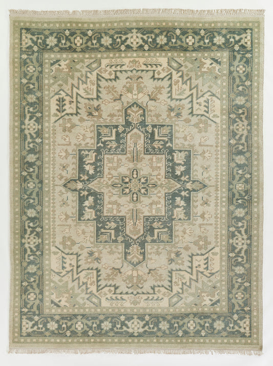 Green and beige oriental rug with a central geometric medallion, teal border, and fringed edges.