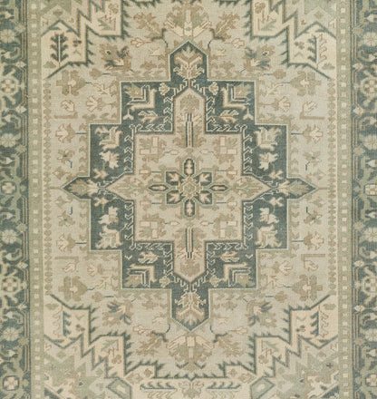 Muted sage, teal and cream oriental rug with a large central cross-shaped medallion and ornate border.