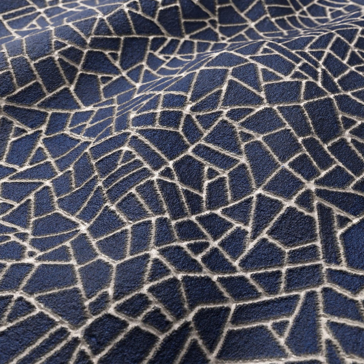 Dark blue textured velvet fabric with a white irregular fractured mosaic pattern.
