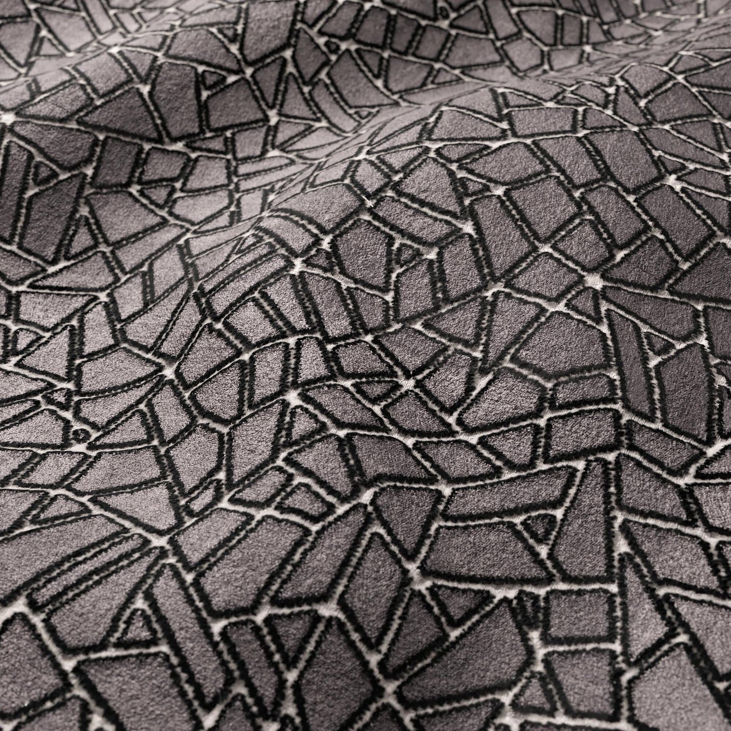 Grey velvet fabric with an irregular polygon mosaic crackle pattern; modern geometric texture.