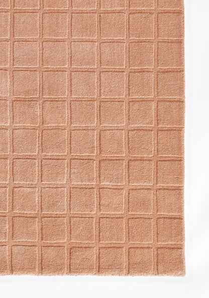 Peach waffle-grid rug with small square pattern and soft cotton texture.