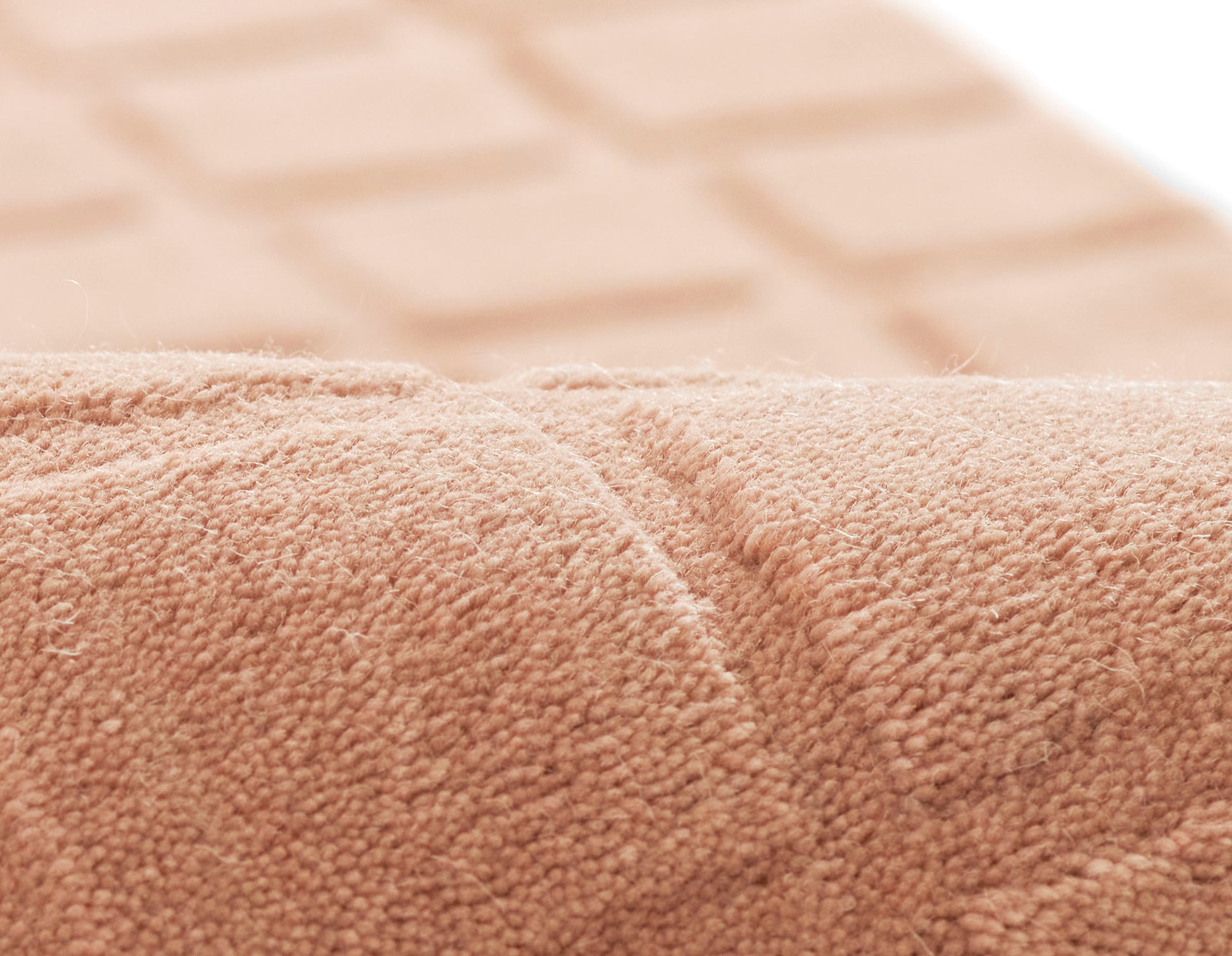 Beige terry cloth towel close-up with plush looped texture and rolled edge for bath use.