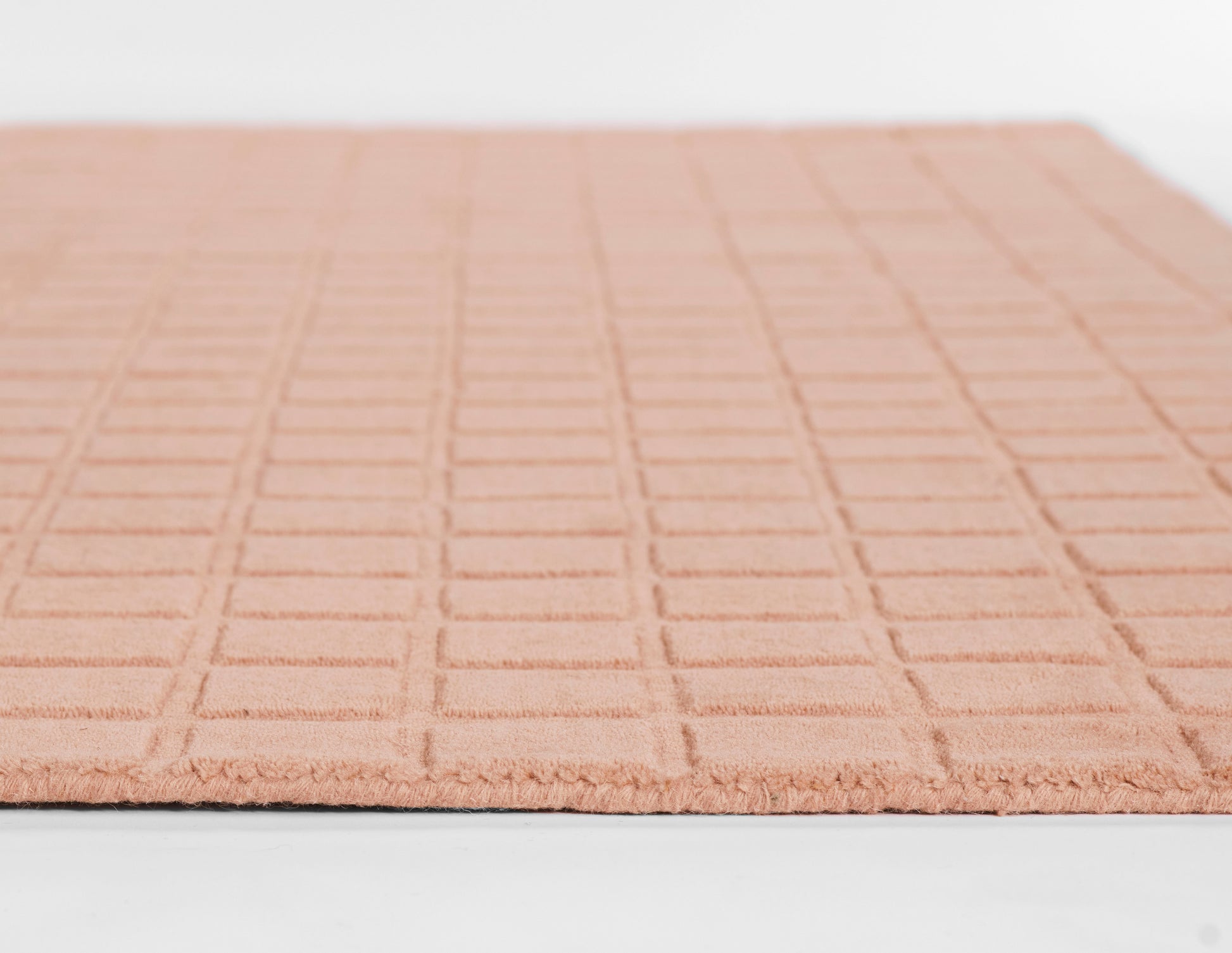 Peach grid-pattern bath mat with plush square-tufted texture; rectangular bathroom rug.