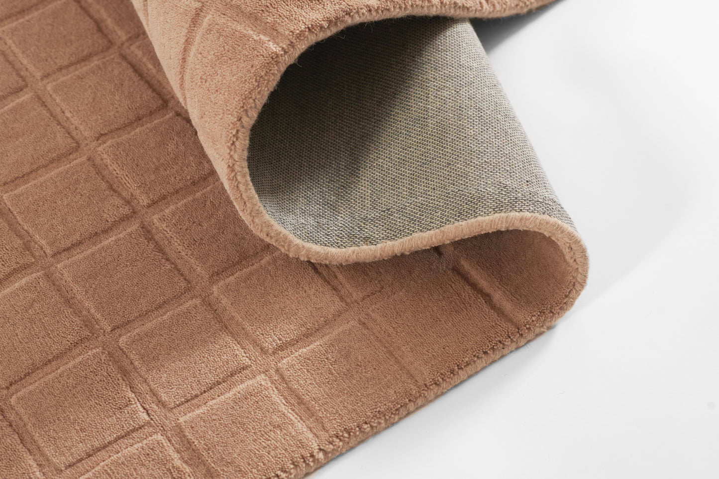 Beige-brown plush bath mat with square quilted grid, soft microfiber top and grey non-slip backing.