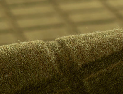 Close-up of olive-green fuzzy rug texture with a seam, size 2' x 3'.