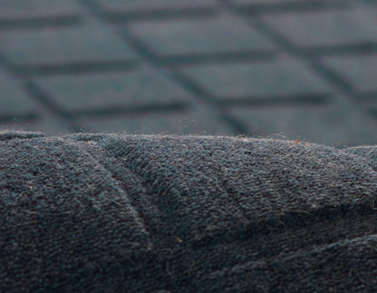 Close-up of dark charcoal suede-like fabric with soft nap & visible seam; close textile texture for upholstery or apparel