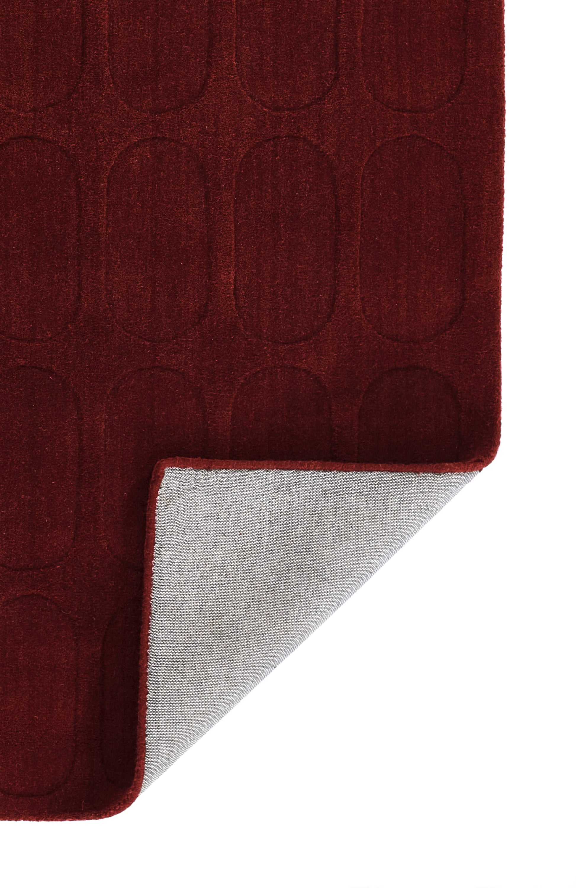 burgundy rug with oval embossed pattern, plush pile; folded corner reveals light gray underside.