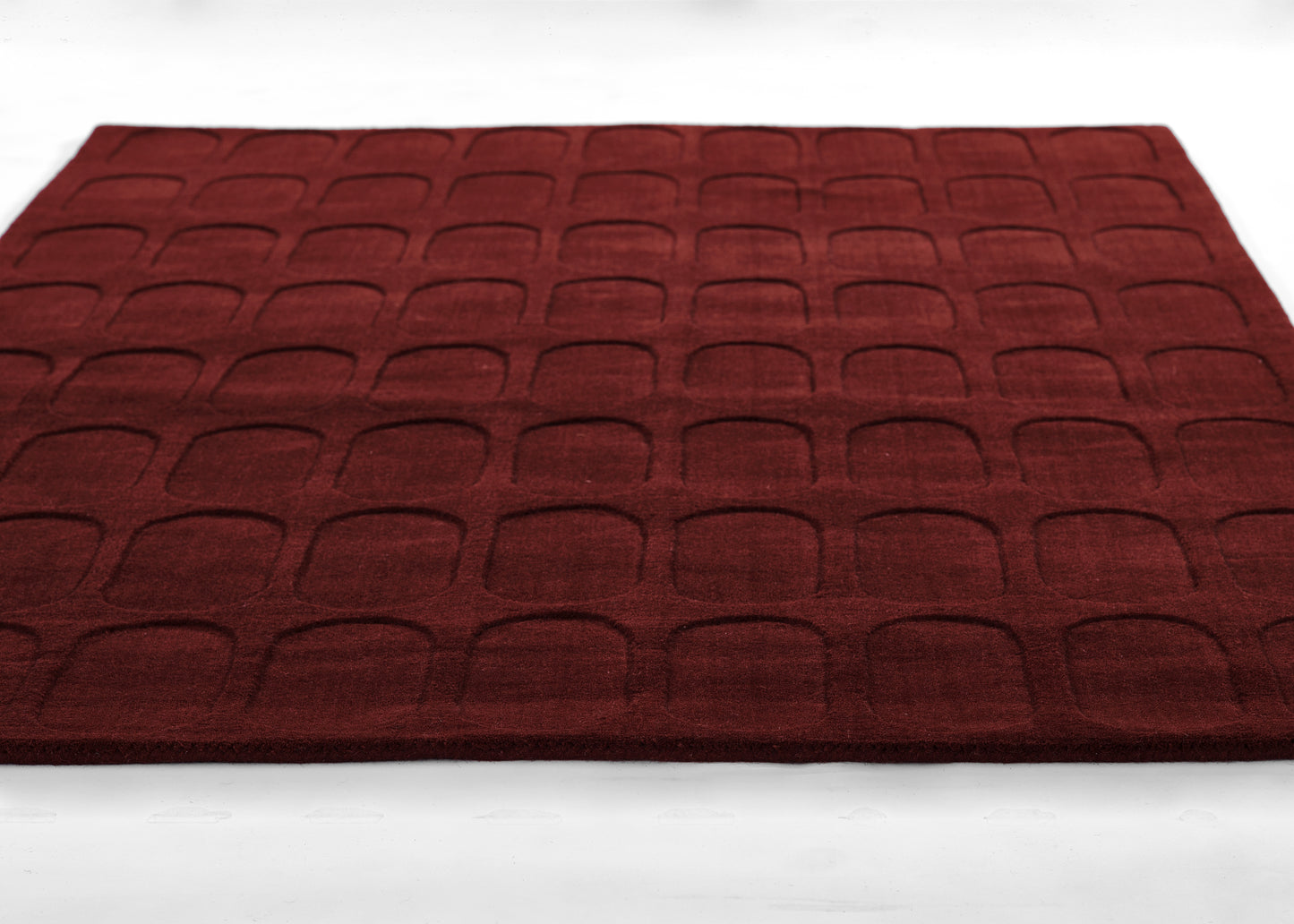 burgundy embossed floor mat with a grid of rounded arches; plush, soft rug for entryway or bathroom.