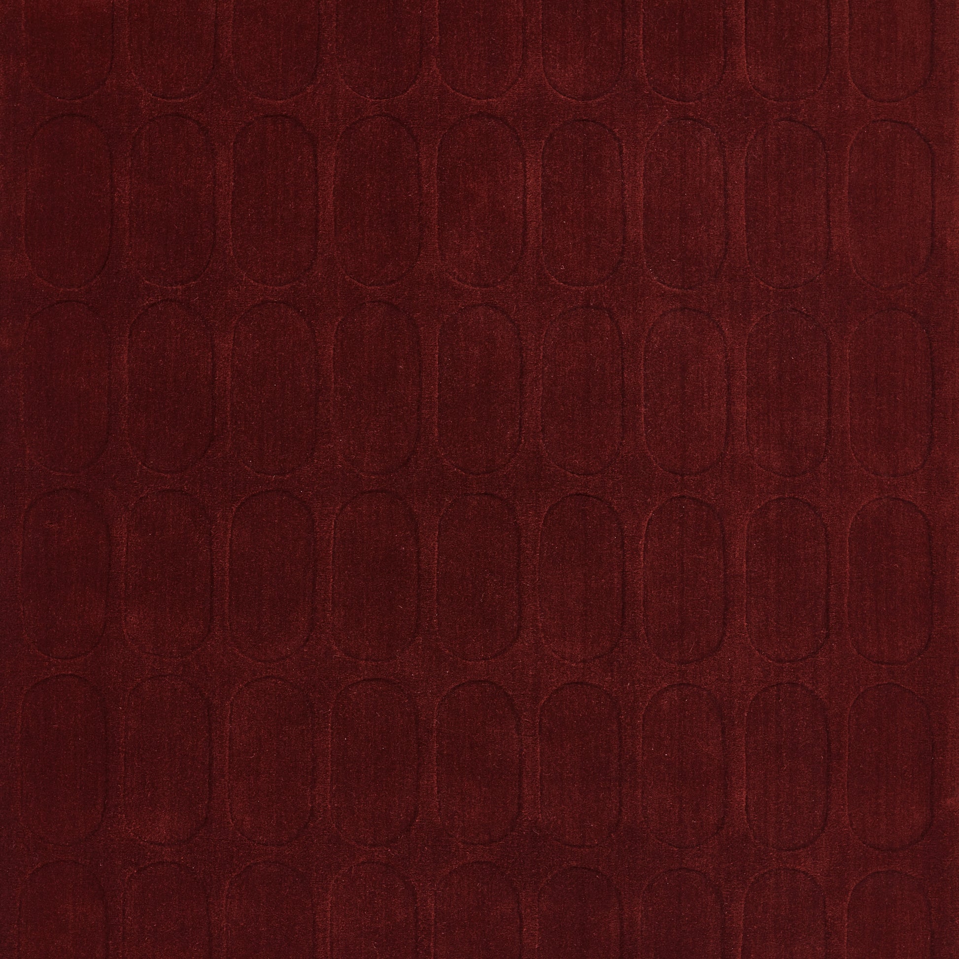 Burgundy rug with a repeating embossed arched-oval pattern and a soft velvet-like texture; 5' x 8'.