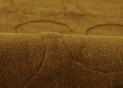 Brown suede-like rug with circular tufting and stitched seams.