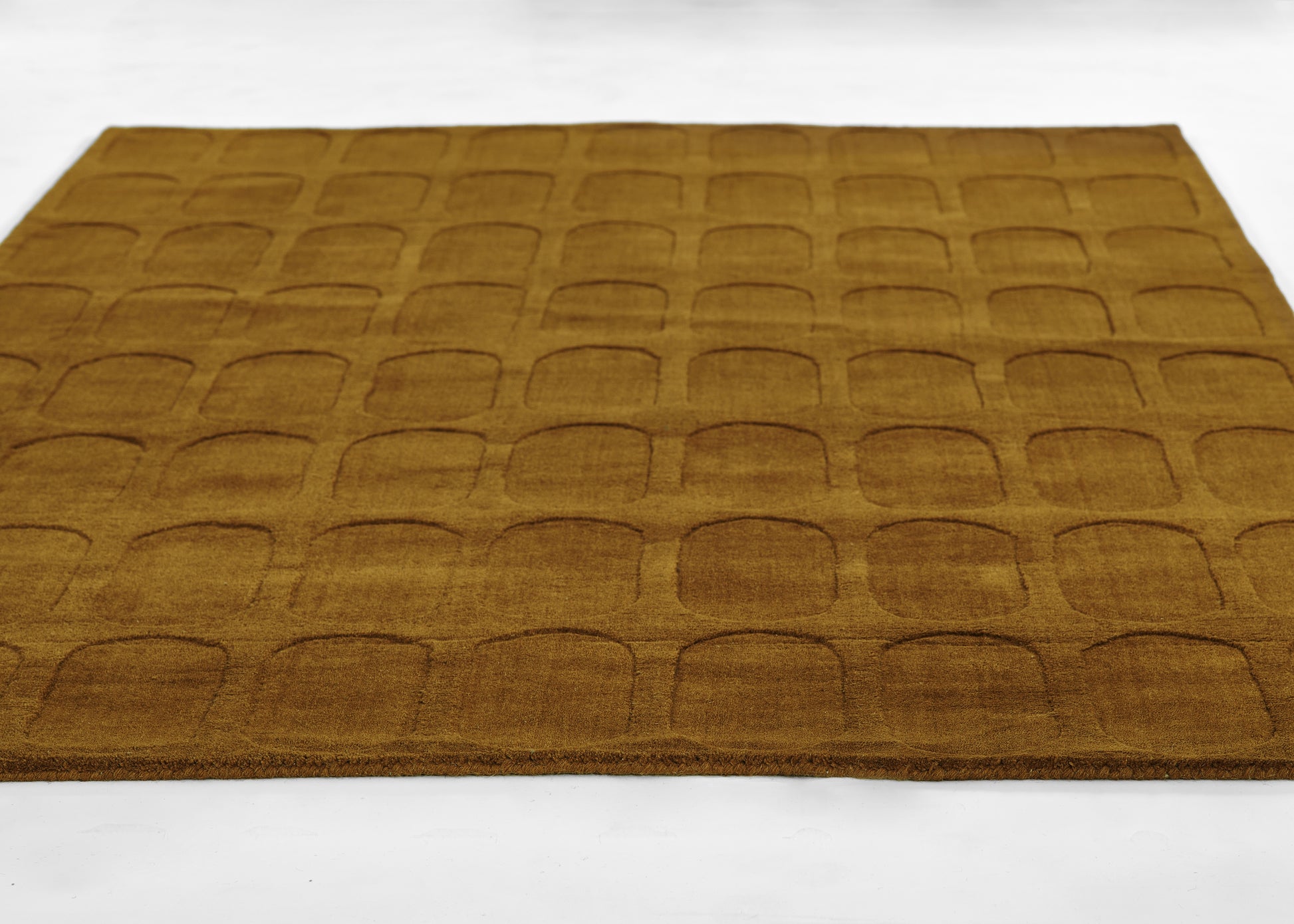 Brown rectangular area rug with embossed repeating rounded-square motif, soft textured, modern decorative mat.