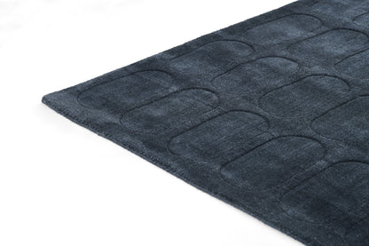 Dark navy plush rug featuring a raised rounded-rectangle tufted pattern.