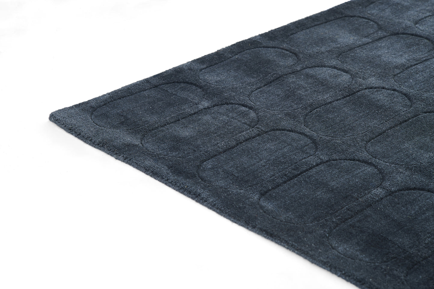 Navy blue plush quilted mat with rounded-rectangle pattern; ideal as a bathroom rug.