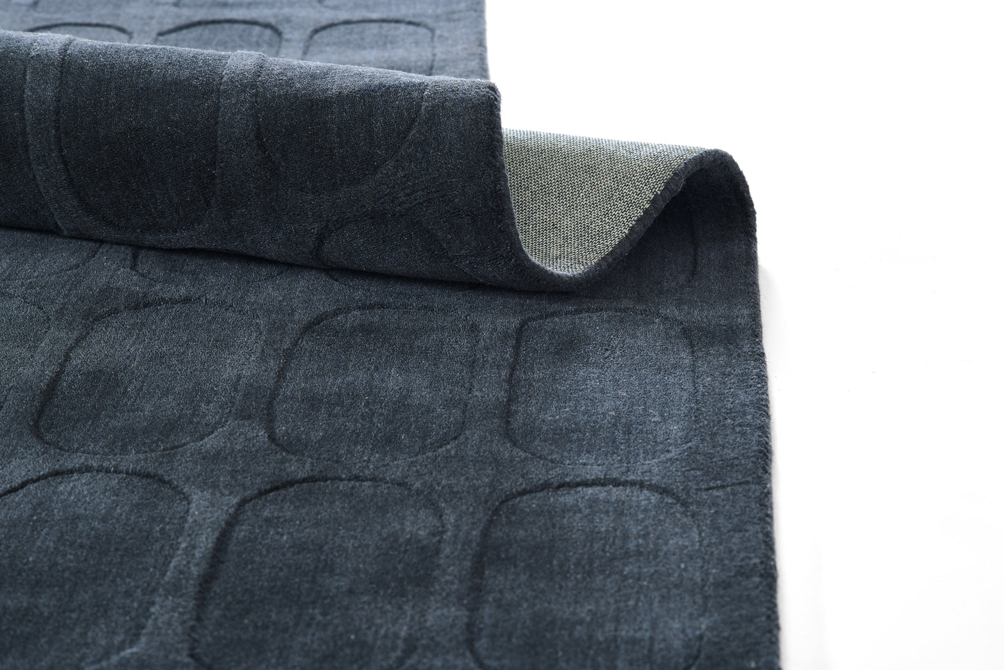 Dark navy quilted rug with rounded rectangle pattern; soft velvety top and beige reverse.